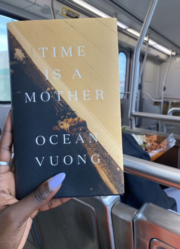 a person holding up a book in their hand that reads time is a mother ocean vuon