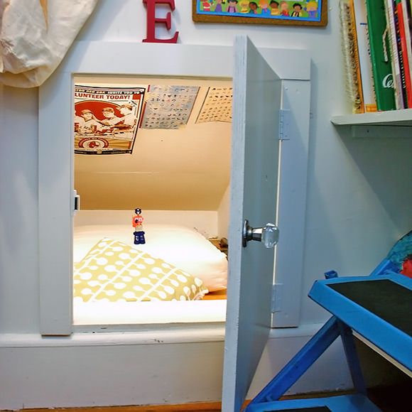 an open door leading to a small room with a bed and desk in it that also has toys on the floor