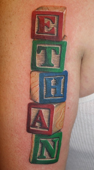 a person with a tattoo on their arm that has blocks in the shape of letters