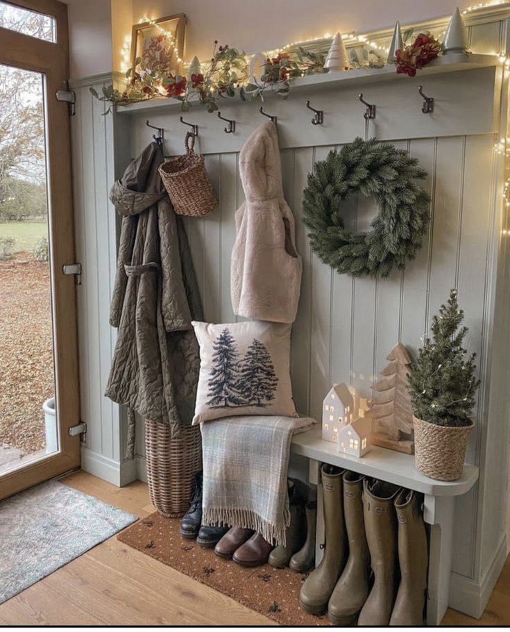 the entryway is decorated for christmas with wreaths, stockings and boots hanging from hooks