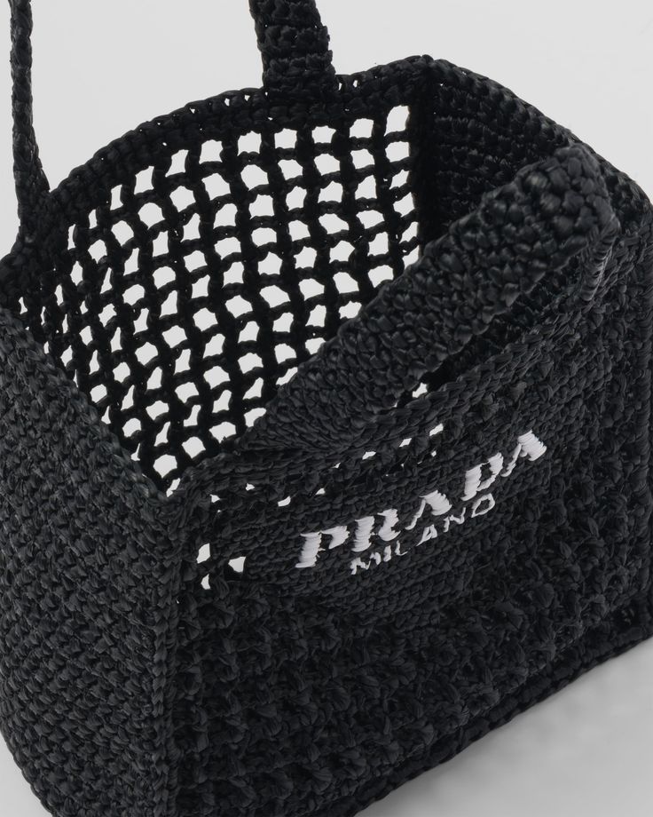 a crocheted black bag with white handles