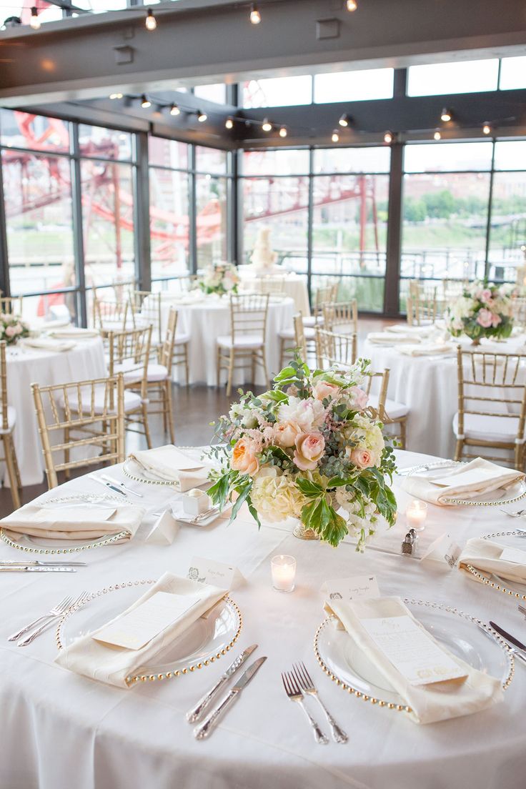 the tables are set with white linens and gold place settings for an elegant wedding reception