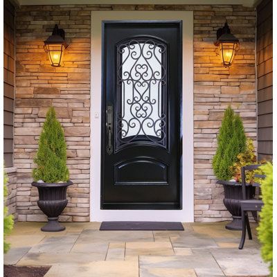 the front door is decorated with potted plants and two large urns on either side