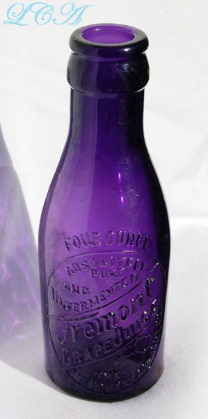 a purple glass bottle sitting on top of a table