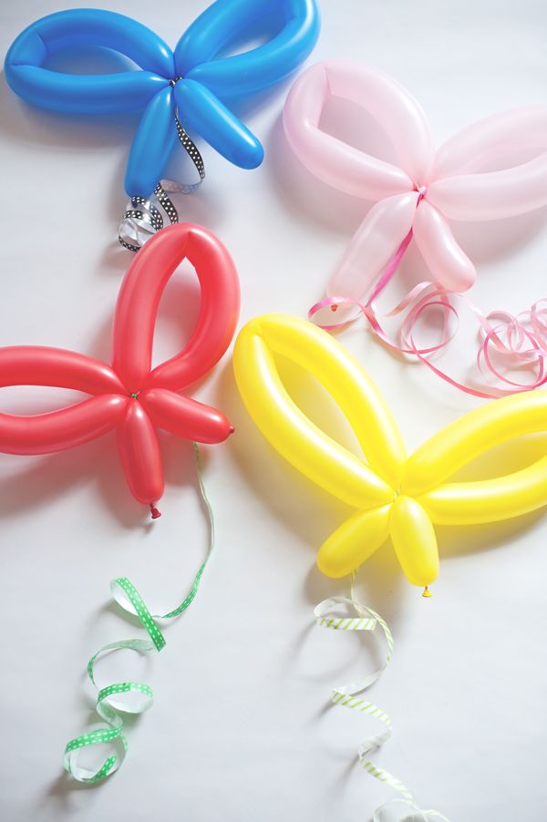 three different colored balloons are laying next to each other on a white surface with the letters love spelled out