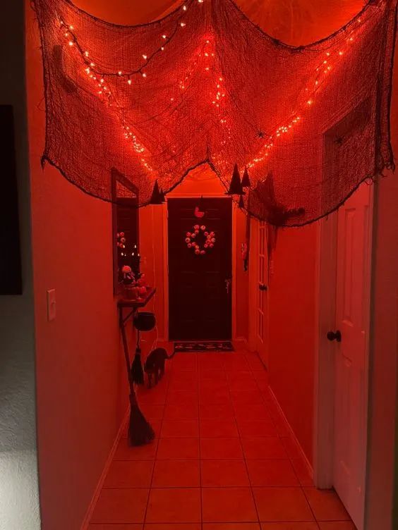 the hallway is decorated with red lights and netted curtains over the door, which are hanging from the ceiling