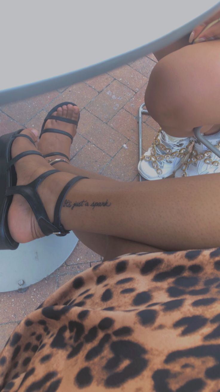 a woman's legs with tattoos and leopard print on the bottom part of her leg