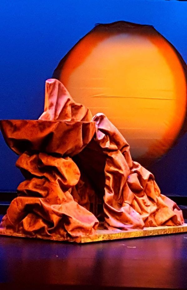 a large orange object sitting on top of a wooden table next to a blue wall