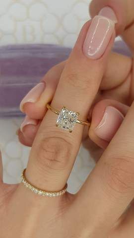 a woman's hand with a ring on it and a diamond in the middle