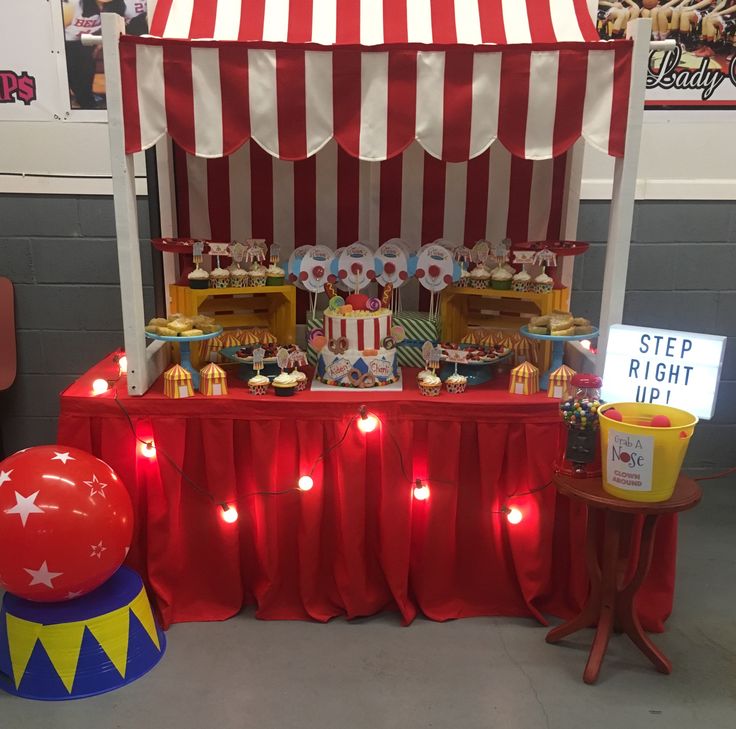 a circus themed dessert table with red and white striped tent