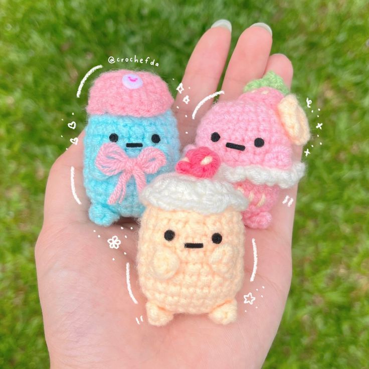 two small crocheted toys are sitting on someone's hand