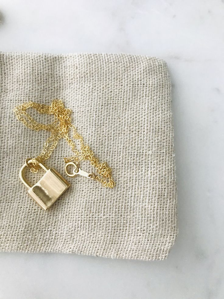 "Padlock Necklace * 14k gold filled Beautiful padlock necklace! The pendant is made of thick 18k gold filled. Great quality and fun to layer with other necklaces. d e t a i l s -- 14k gold filled chain -- 14k gold filled spring clasp closure -- 18k gold filled padlock measure 20MM * model is wearing 18\" Necklace comes in a kraft jewelry box with a bow on top h o w * t o * o r d e r 1. please select options from the dropdown menu 2. add to cart and proceed to checkout 3. then place your order g 14k Gold Necklace With Gold Clasp For Gift, Minimalist Lock Jewelry For Gifts, Minimalist Lock Jewelry As Gift, Minimalist Jewelry With Lock As A Gift, Minimalist Lock Jewelry As A Gift, 14k Gold Jewelry With Gold Clasp For Gift, Gold Necklace For Everyday Use, Everyday Gold Lock Jewelry, Everyday Gold Jewelry With Lock Detail