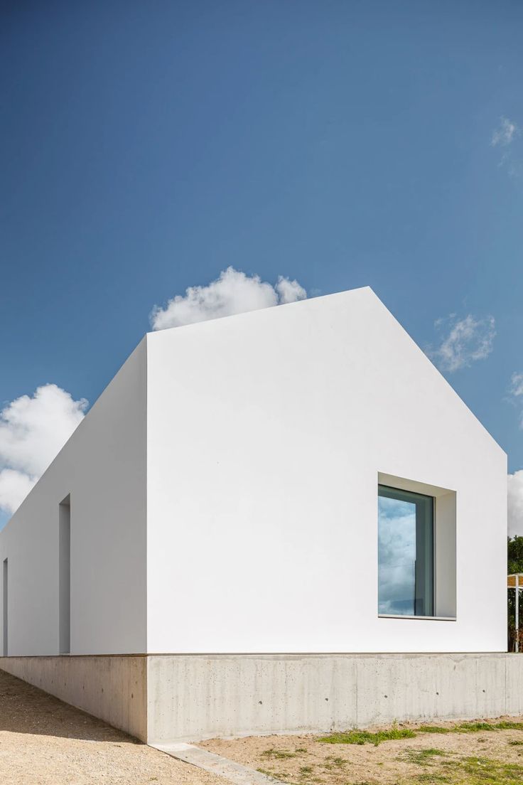 a white house sitting on top of a dirt field