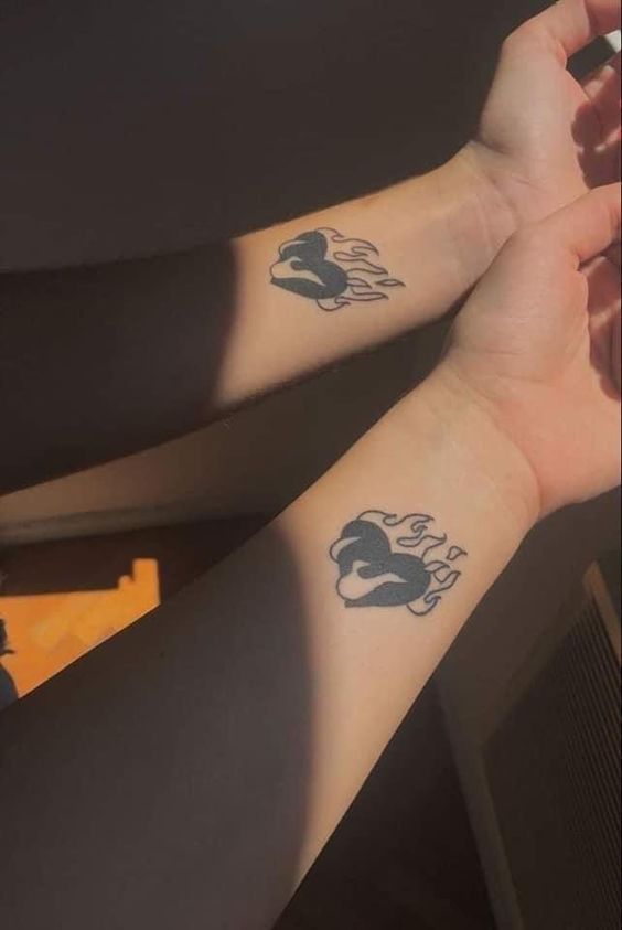 two people with matching tattoos on their arms