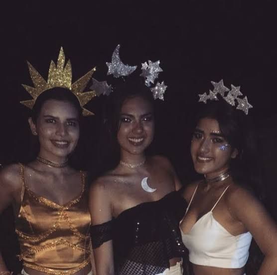 three women dressed in costumes posing for a photo