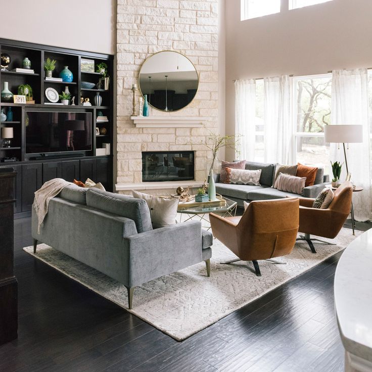 a living room filled with furniture and a fire place in the middle of a room