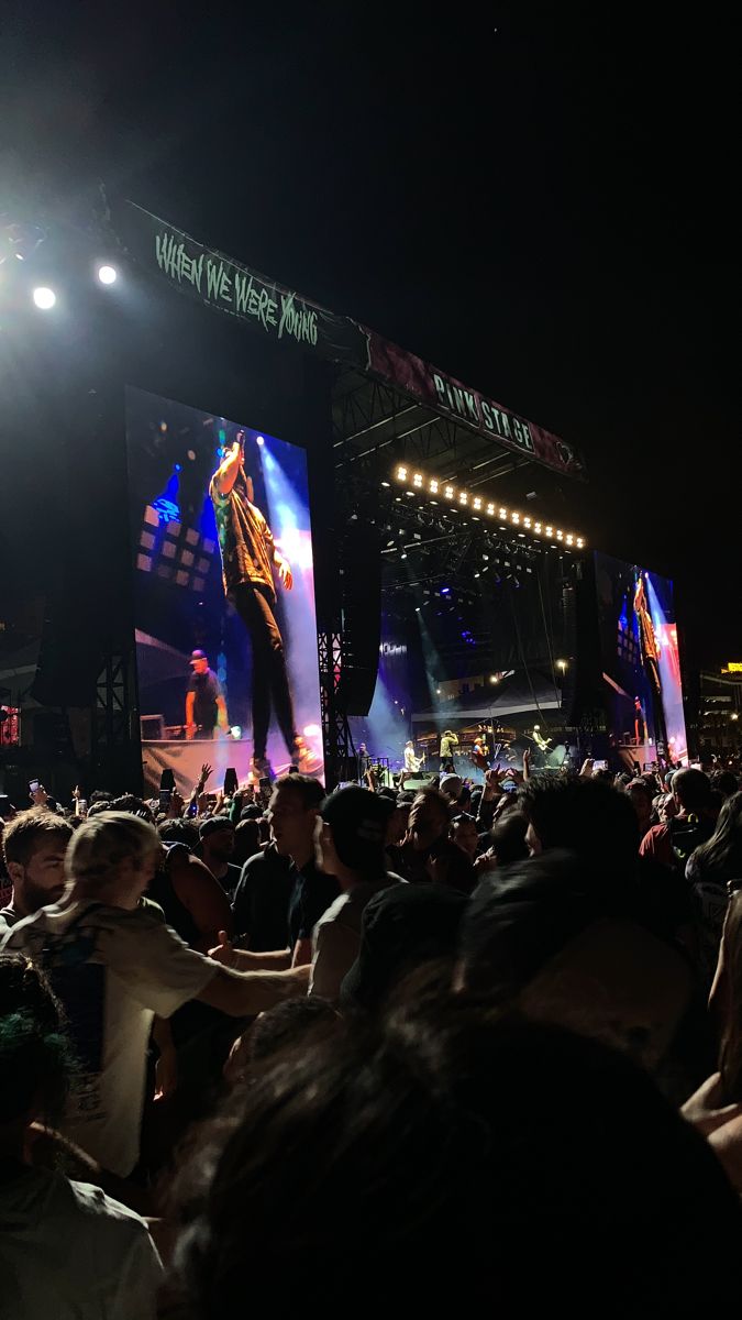 a large group of people standing on top of a stage next to each other in front of a crowd