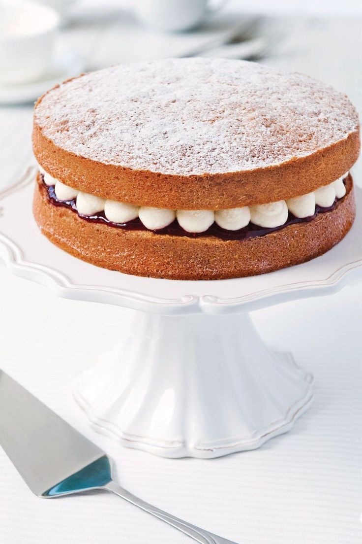 a cake sitting on top of a white plate next to a knife and fork in front of it