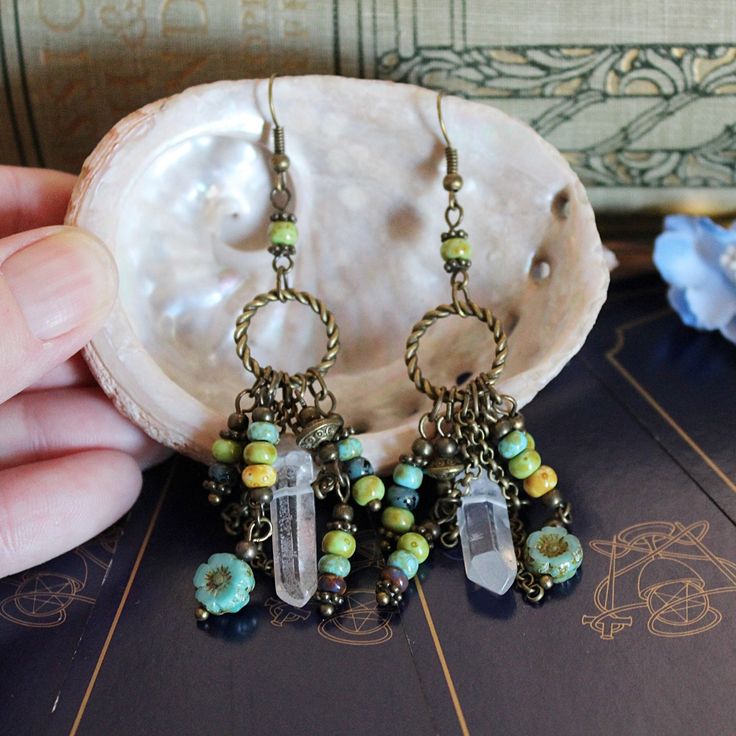 Australian made, Earth goddess bohemian earrings for your boho pagan jewelry collection! Handcrafted beaded chandelier earrings with a hippie witchy tribal vibe These long dangling ooak, handmade statement earrings were created with... Rustic Czech glass beads. Czech flower beads. Quartz crystal points. Bronze chain. Bronze circles. These long dangle drop earrings measure 8 cm long.  These bronze boho crystal earrings weigh 6 grams each. The perfect accessory to create that green witch style!  A Bohemian Wire Wrapped Chandelier Earrings For Festivals, Wire Wrapped Chandelier Earrings For Festivals, Bohemian Dangle Brass Jewelry, Bohemian Brass Dangle Jewelry, Bohemian Wire Wrapped Earrings For Festivals, Bohemian Chandelier Earrings With Ear Wire For Festivals, Bohemian Wire Wrapped Adjustable Chandelier Earrings, Bohemian Adjustable Wire Wrapped Chandelier Earrings, Bohemian Chandelier Earrings For Pierced Ears