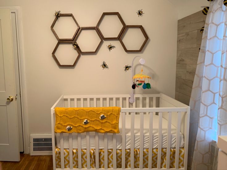 a baby's room with honeycombs on the wall and a white crib