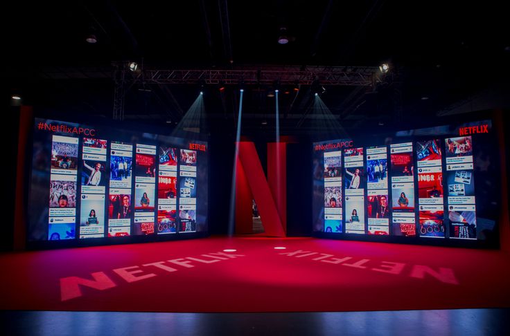 a red carpeted room with two large television screens on it's sides and the words netflix written across the screen