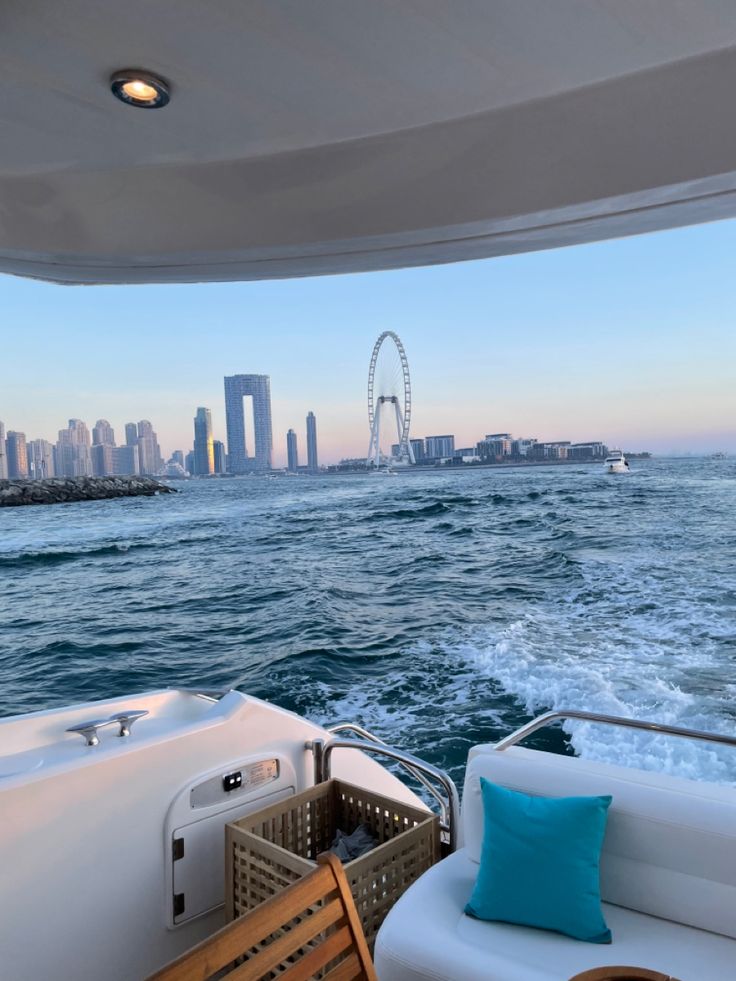 the back end of a boat in the water with a city skyline in the background