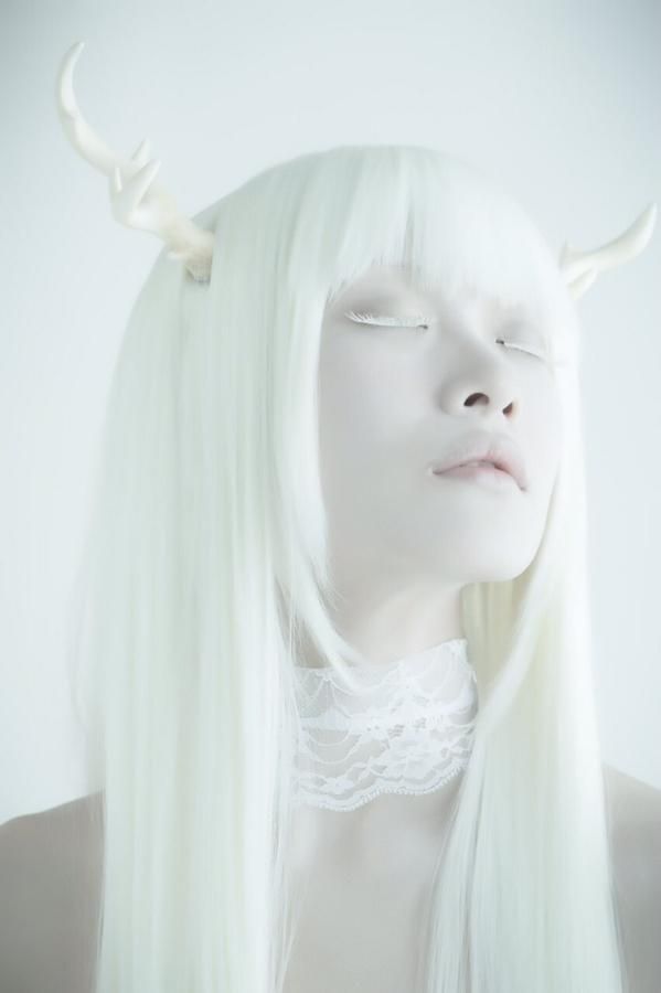 a woman with long white hair and horns on her head