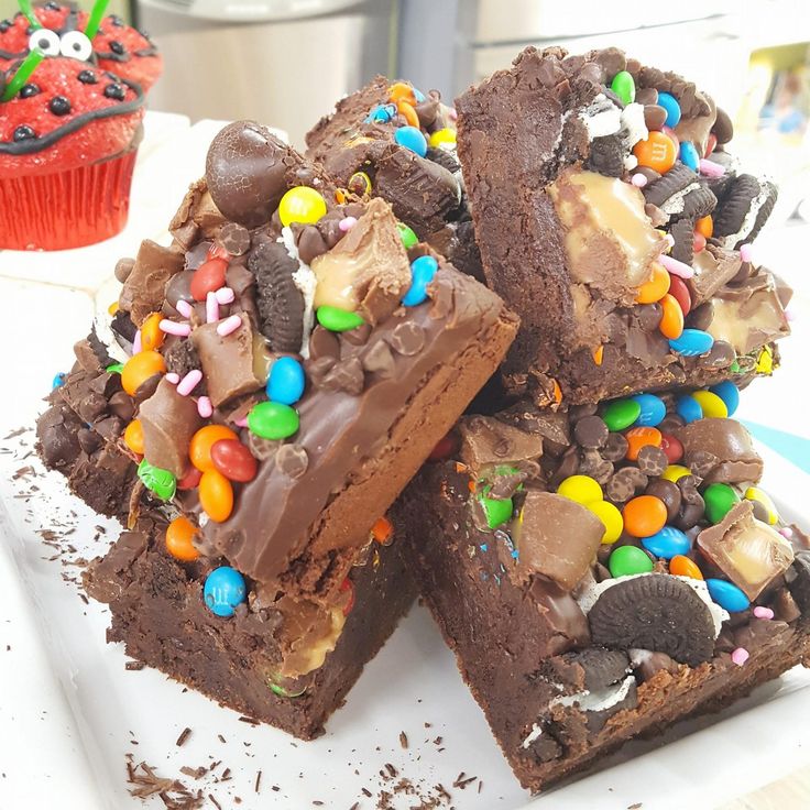 a white plate topped with brownies covered in candy