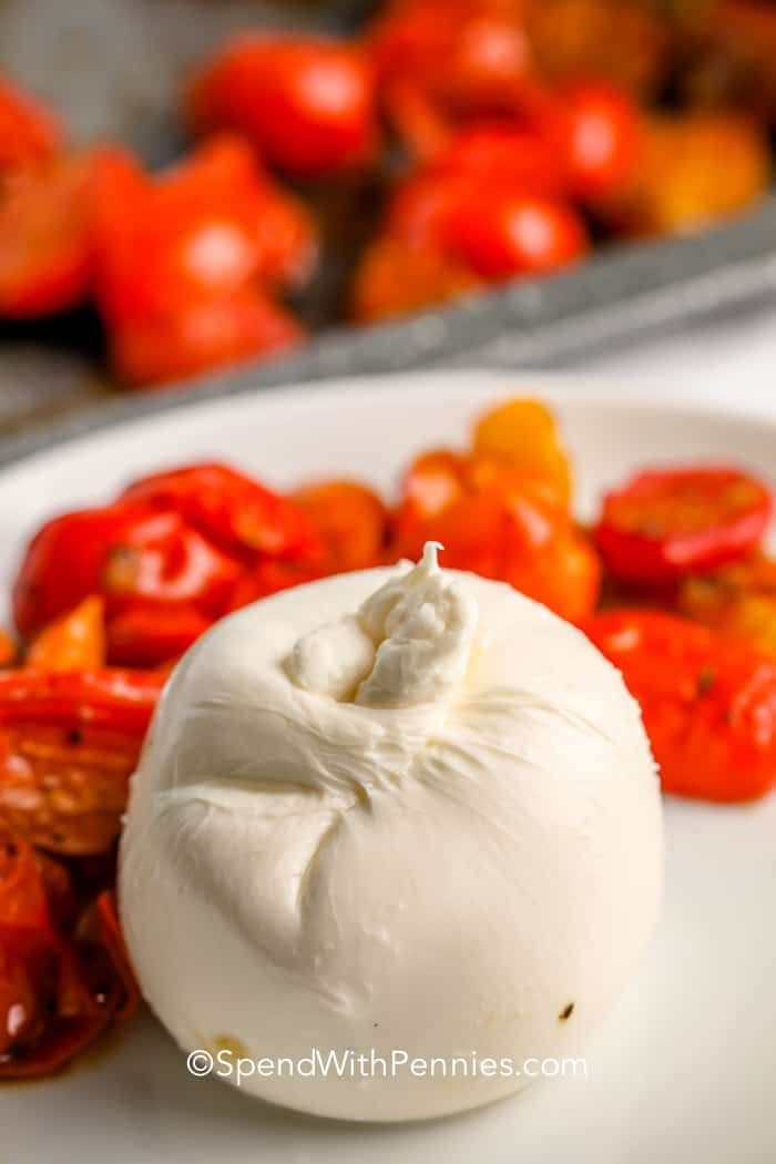 a close up of a plate of food with tomatoes and other foods in the background