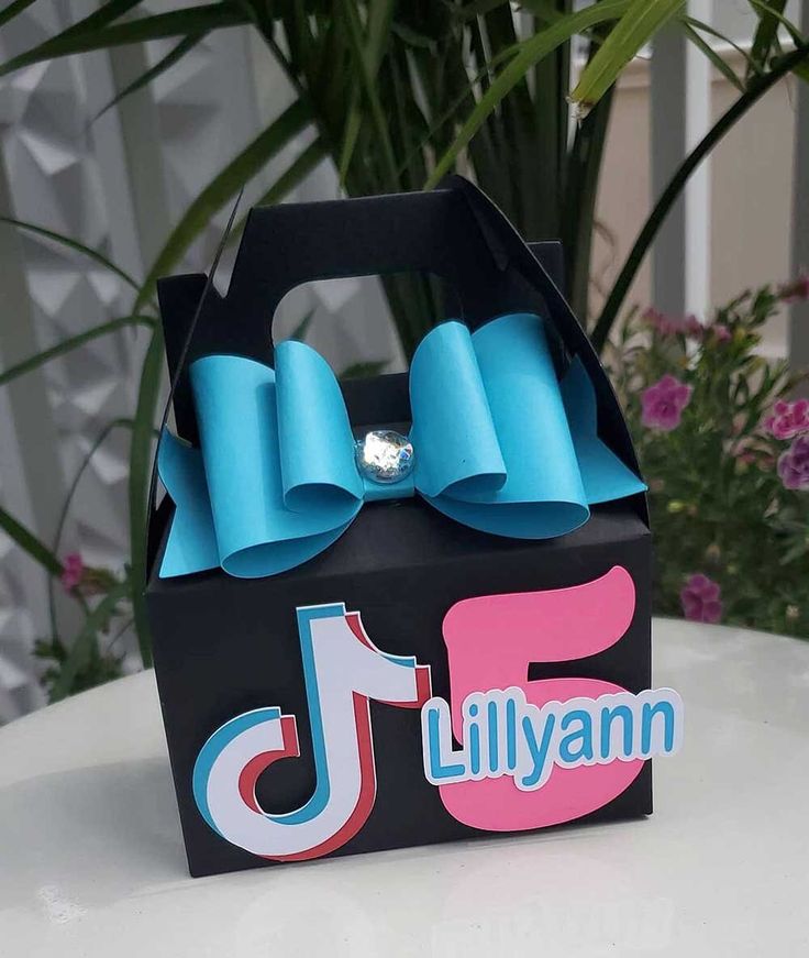 a small black box with blue bows on the top and name lilyann written on it