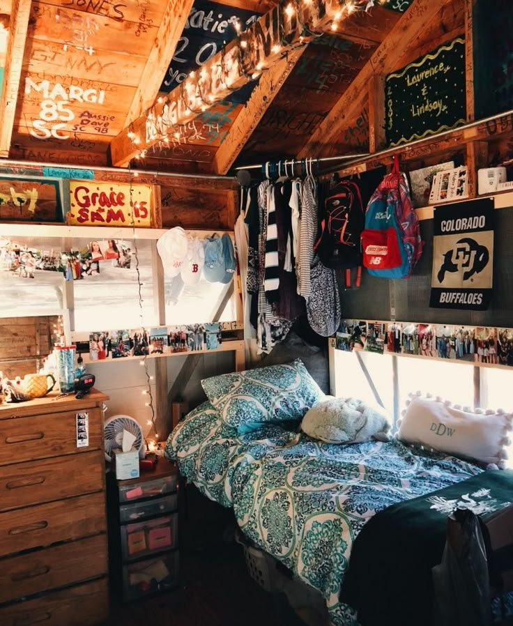 a bed room with a neatly made bed and lots of pictures on the wall above it