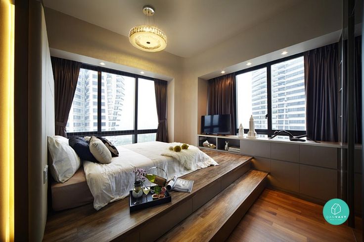 a large bed sitting in the middle of a bedroom next to a tv on top of a wooden shelf