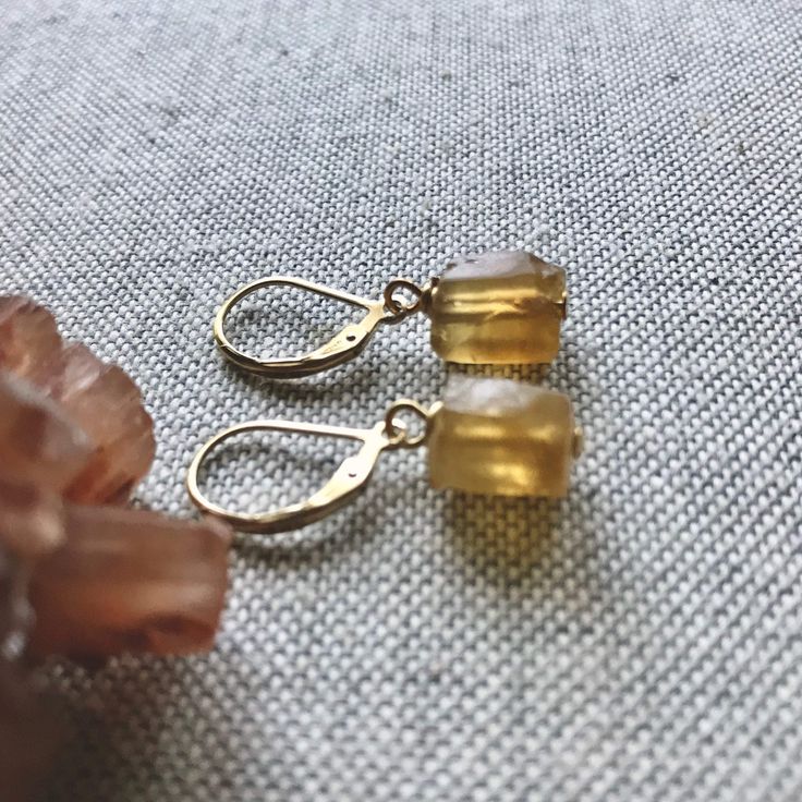 ★Metal- Gold Fill Ear Wires ★Stone- Genuine Raw Citrine ★ 1.2 inches long ★We want you to love your new jewelry and gladly accept returns. ★Arrives ready for gifting (example in last photo) and usually ships same day or next day. Check shop announcement for occasional delays. Gorgeous raw citrine in all it's warm, sunny beauty hang from high quality gold fill lever backs ear wires. Each pair is unique and ready to gift to that someone special. Citrine is the birthstone for November. ✧Metaphysica Turquoise Earrings Gold, Raw Crystal Earrings, Raw Stone Earring, Raw Stone Necklace, Raw Citrine, Raw Crystal Necklace, Stone Dangle Earrings, Citrine Earrings, Citrine Necklace