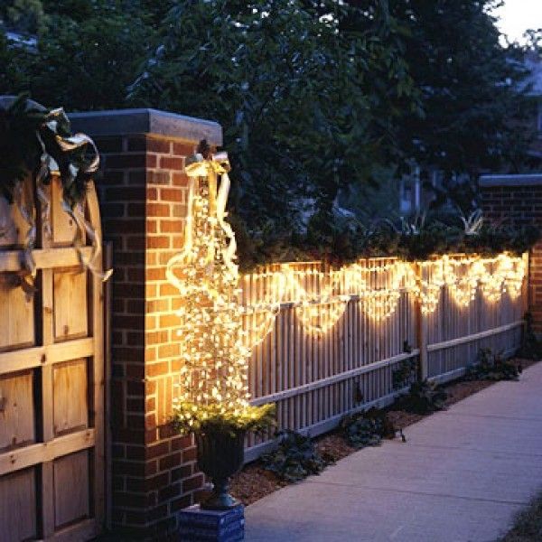 a brick fence with christmas lights on it