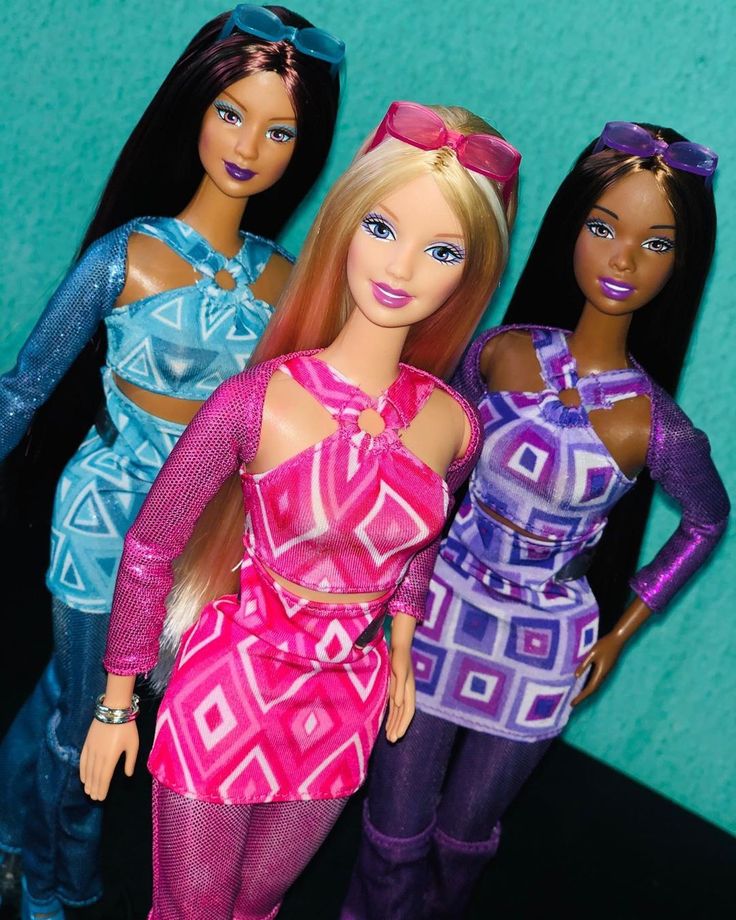 three barbie dolls standing next to each other