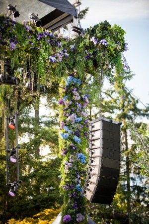 an outdoor stage decorated with flowers and music equipment