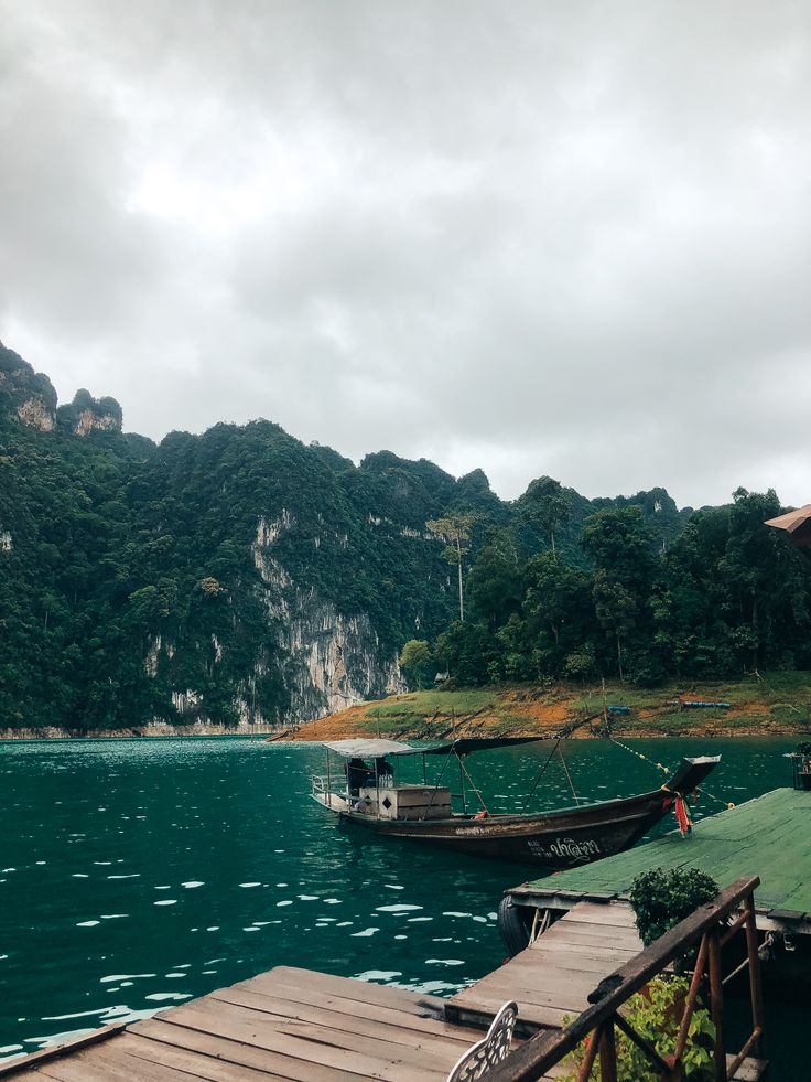 two boats are docked on the water near some mountains