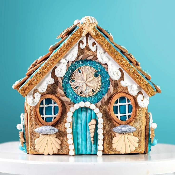 a blue and white clock on top of a small house shaped like a beach hut