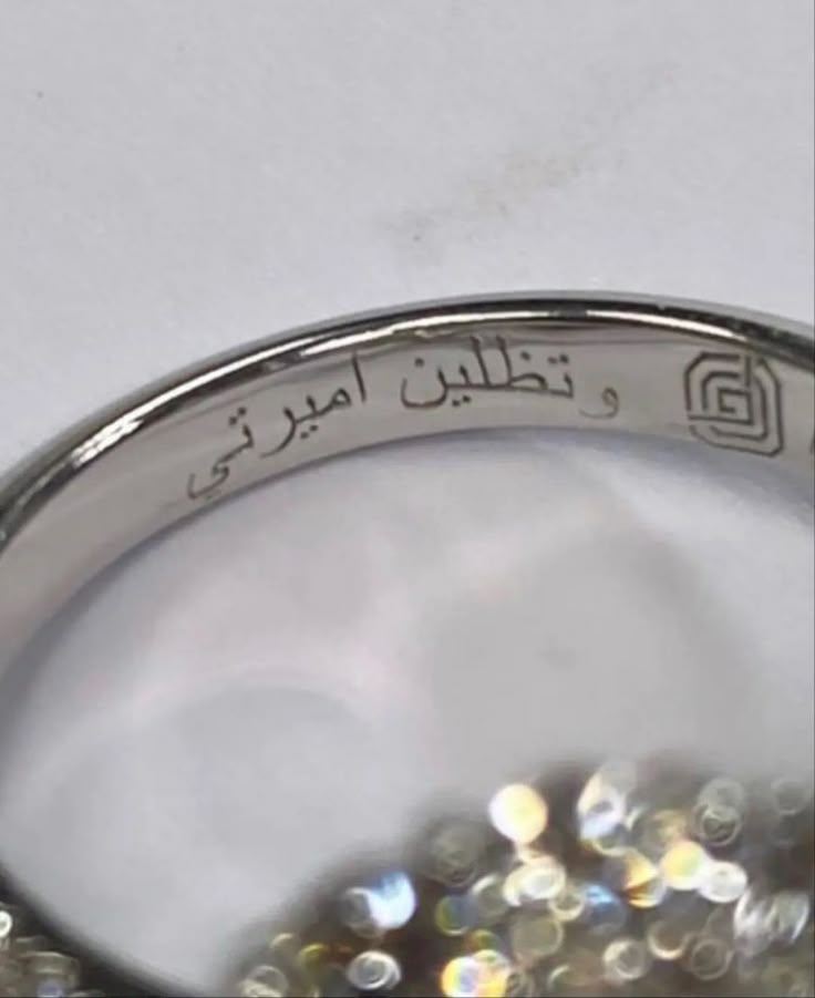 a ring with arabic writing on it and lots of small beads in the bottom half