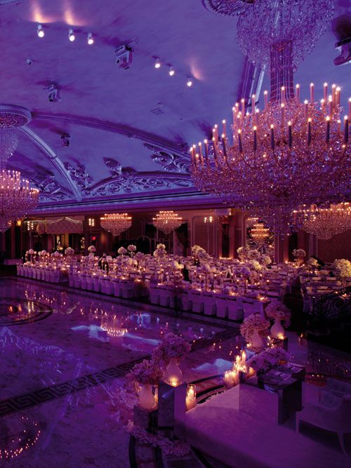 a banquet hall with chandeliers and tables set up for formal function in purple hues