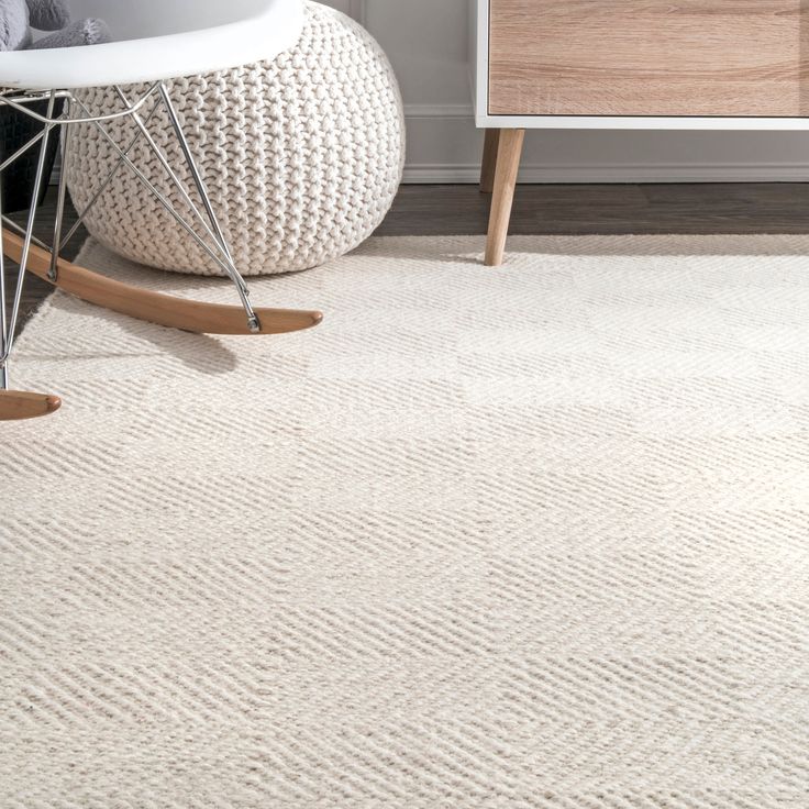 a white rug in a room with a rocking chair and sideboard on the floor