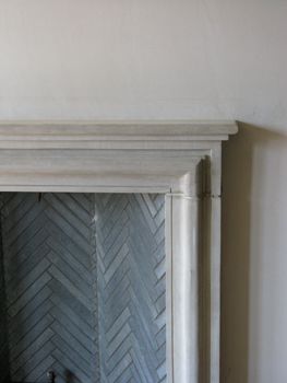 an old fireplace with white paint and herringbone pattern