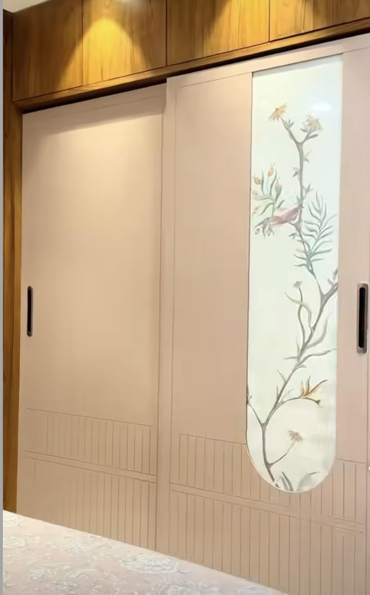 two doors with flowers painted on them in front of a bed and wall mounted lights