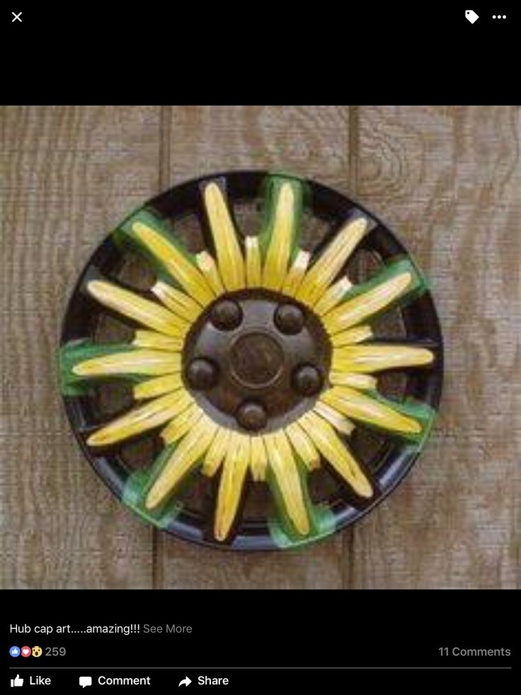 a black plate with yellow and green decorations on it's rim, sitting on a wooden surface