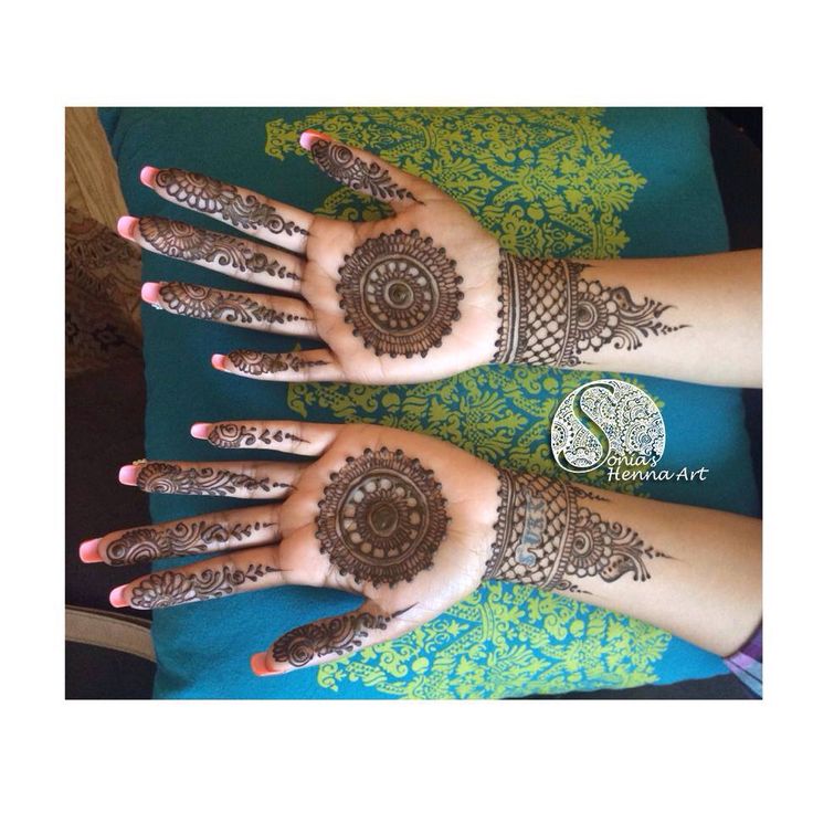 two hands with henna tattoos on them