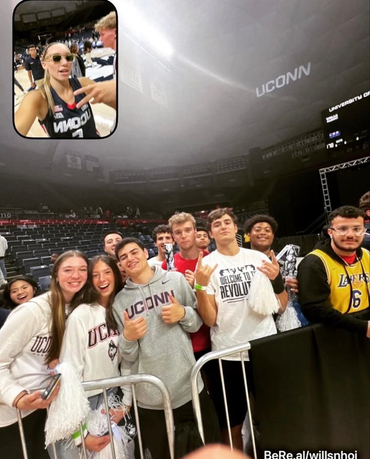 a group of young people standing next to each other in front of a basketball court