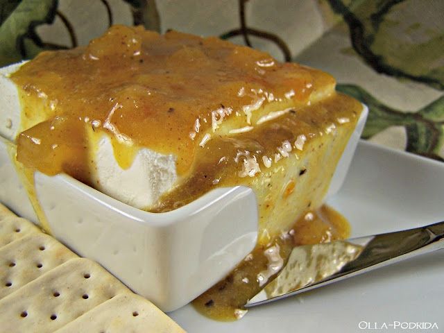 a white plate topped with a piece of cake covered in caramel sauce next to crackers