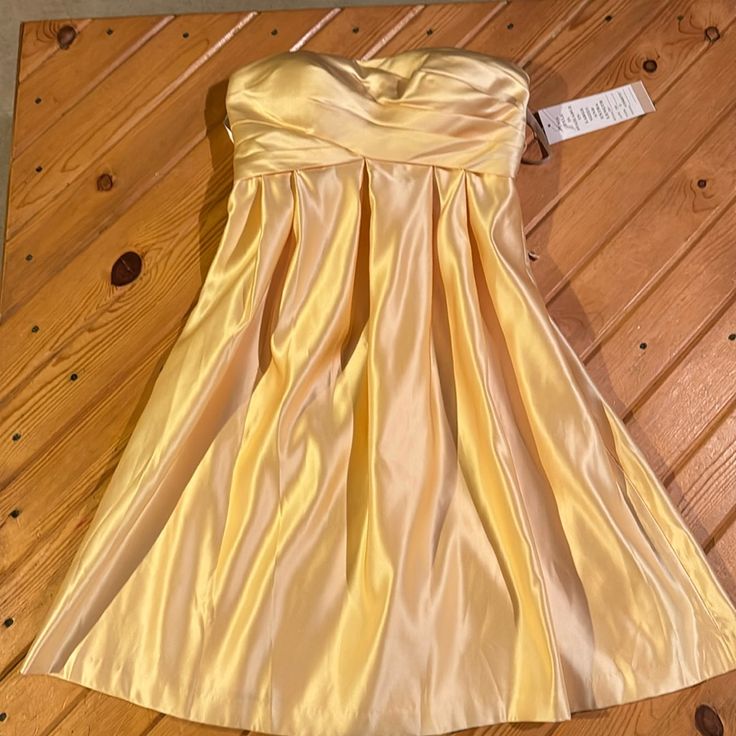 a yellow dress sitting on top of a wooden floor