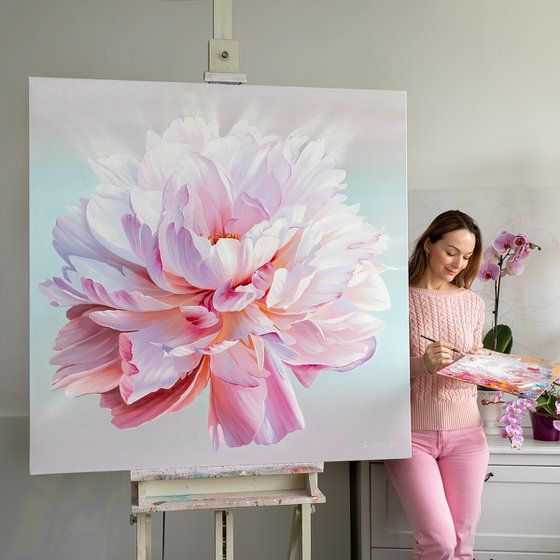 a woman standing in front of a large flower painting