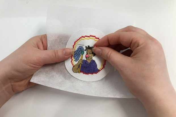 someone is making a cross stitch snowman ornament on a piece of paper